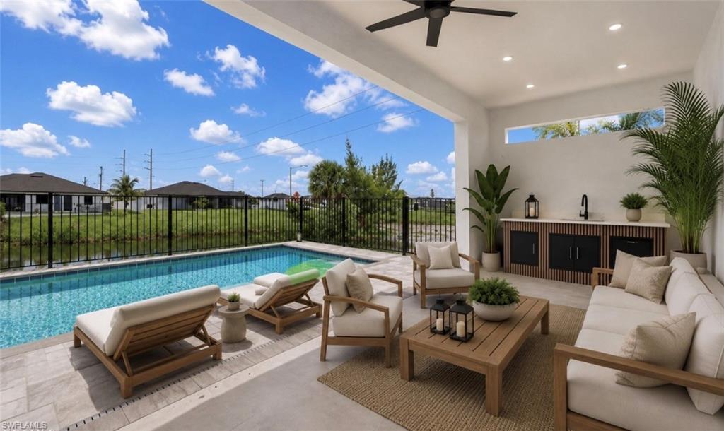 Covered patio with a built-in outdoor kitchen, recessed lighting, ceiling fan, and direct access to the swimming pool