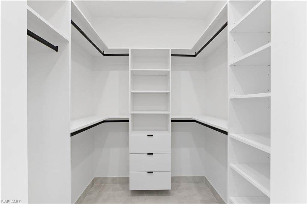 Customizable built-in closet system featuring white shelving, drawers, and matte black hanging rods