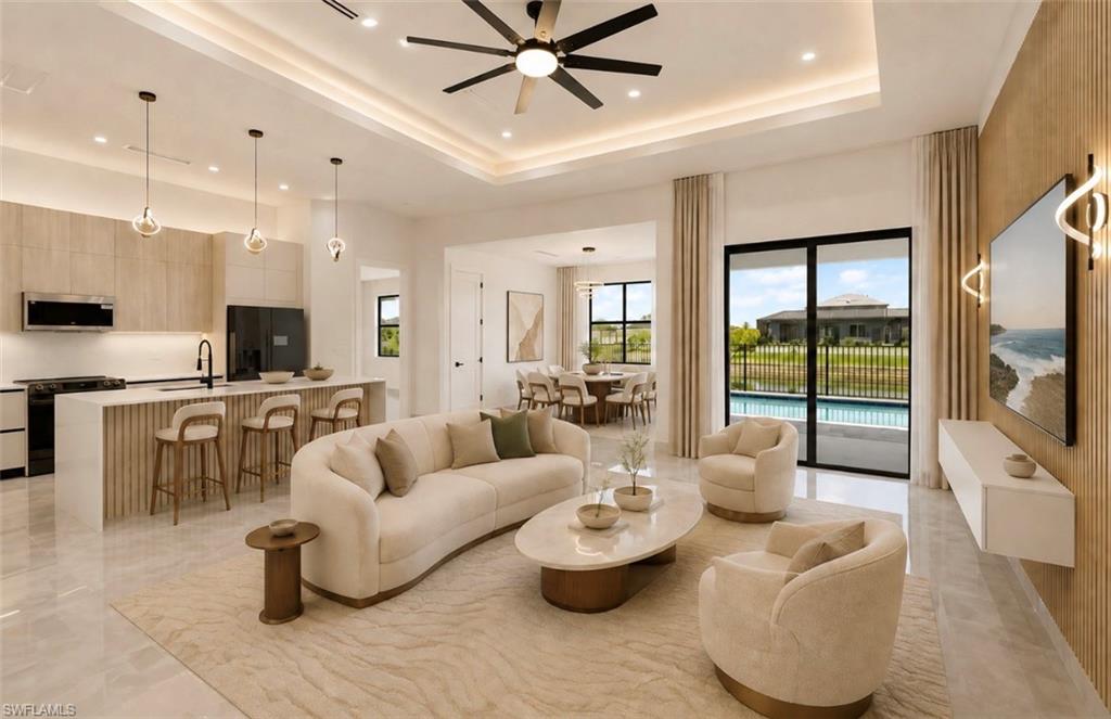 Open-concept living space with large format tile flooring and tray ceiling