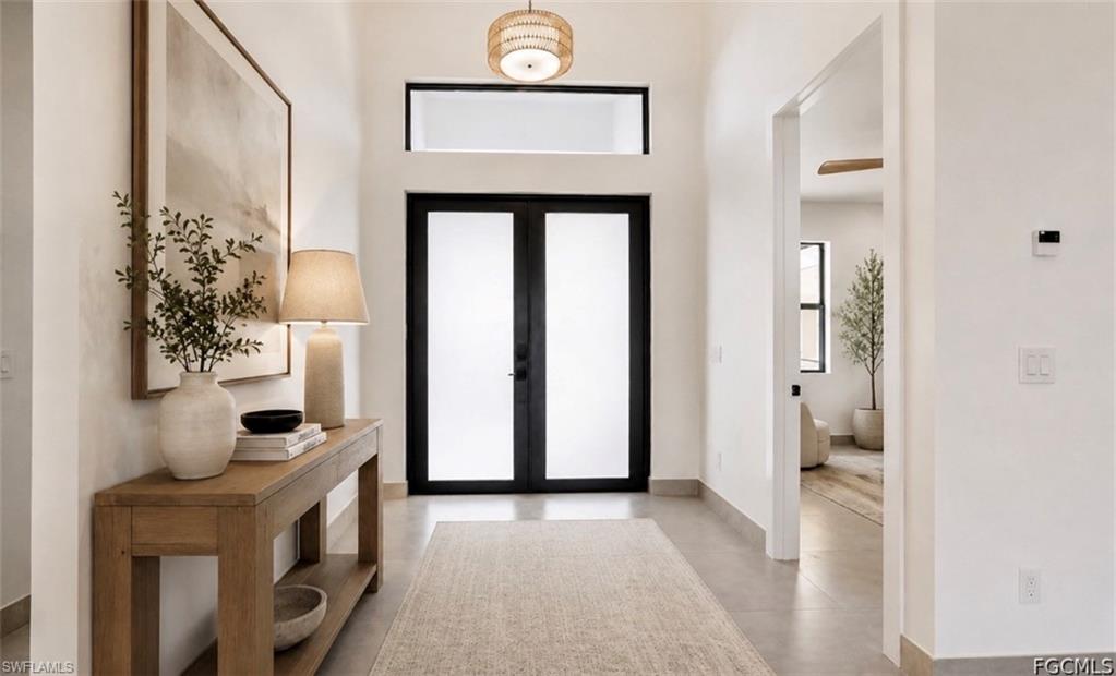 Double entry doors with frosted glass, transom window, recessed ceiling, tile flooring, and neutral wall tones