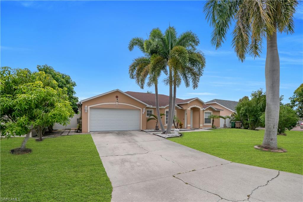 Property exterior featuring a concrete driveway, attached garage, and mature palm trees