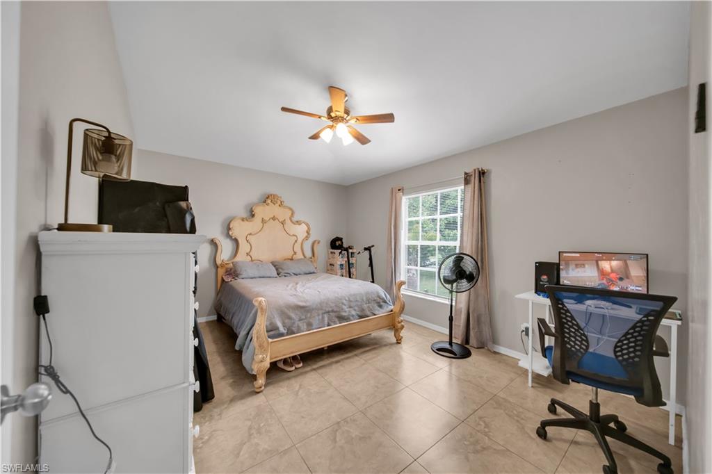 Tile flooring, a ceiling fan with integrated lighting, a double-hung window, and neutral wall tones