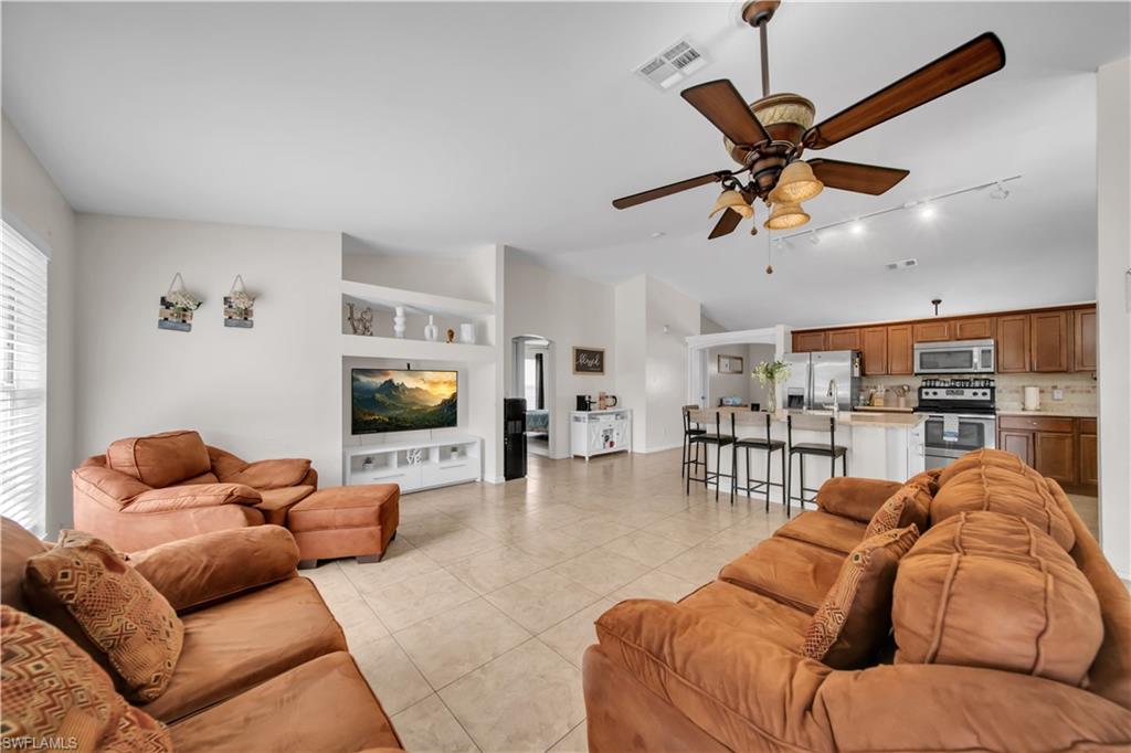 Open-concept living area with tile flooring and a ceiling fan with light fixture
