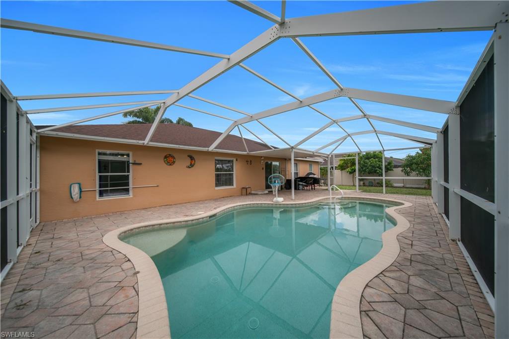 Screened-in outdoor pool featuring a freeform shape and integrated steps
