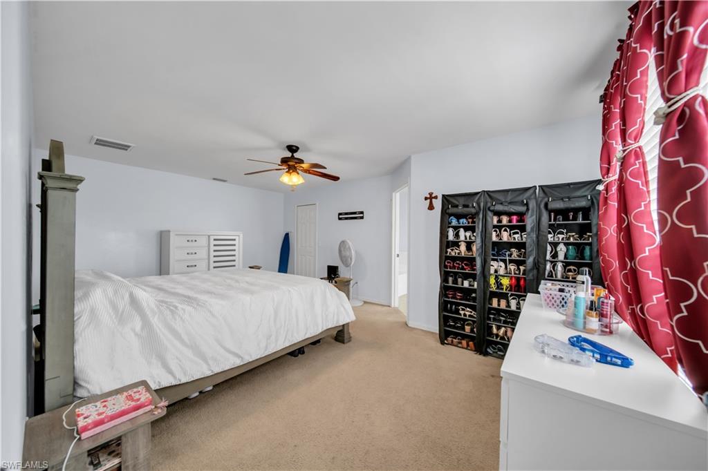Carpeted room featuring a ceiling fan, light blue wall paint, and white trim
