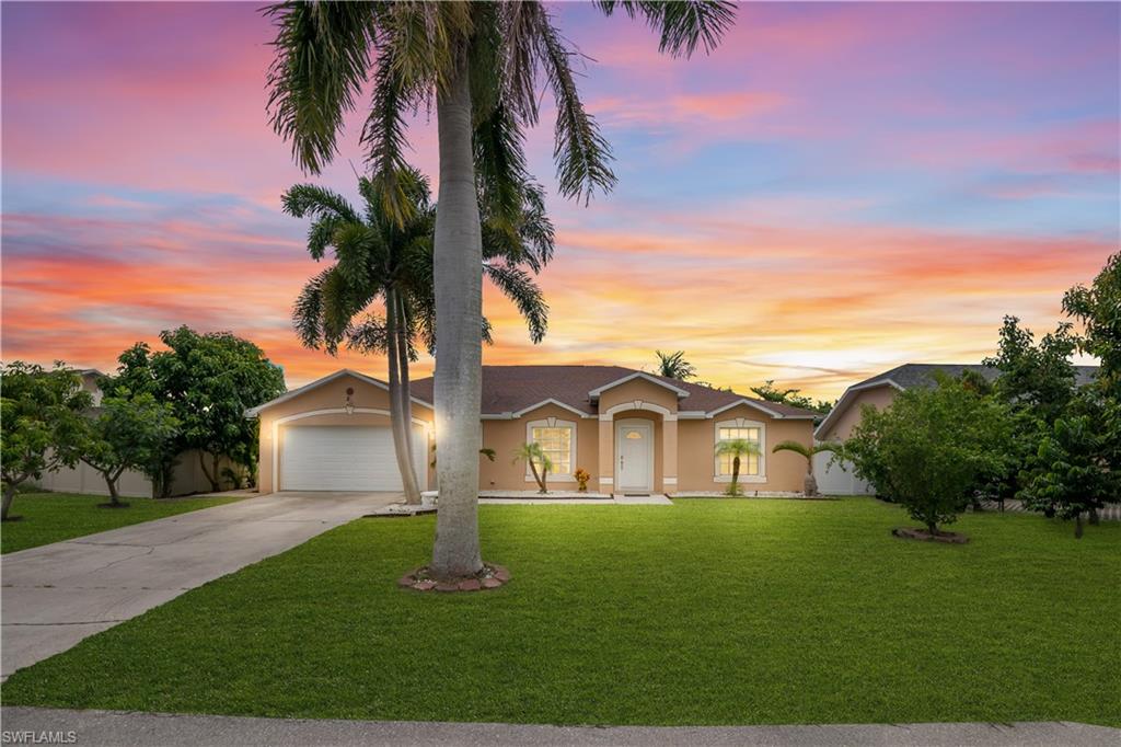 Single-story residence featuring a tan exterior, attached garage, and a concrete driveway