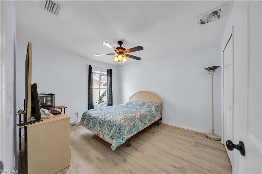 Wood-finish flooring, ceiling fan with integrated lighting, single window, and a built-in closet with bifold doors