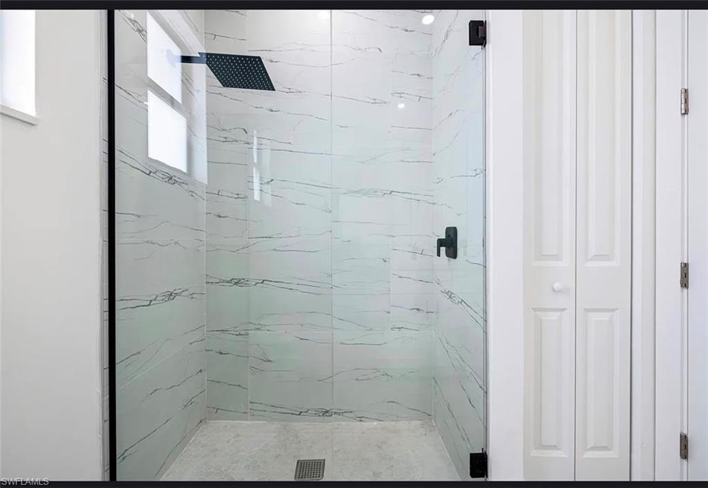 Walk-in shower with clear glass enclosure and black hardware