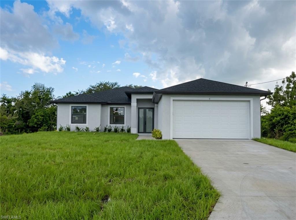 Single-story stucco exterior with a dark shingle roof, attached garage, and a concrete driveway