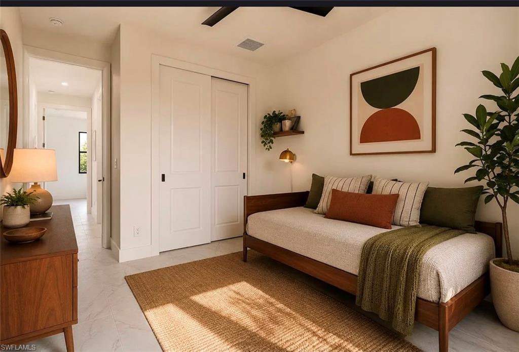 White paneled sliding closet doors, ceiling-mounted light fixture, white walls, and light-toned flooring