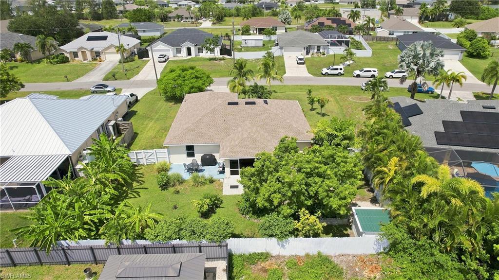 Rear yard with mature landscaping and a concrete patio