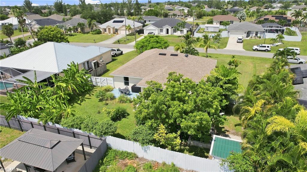Fenced backyard with mature trees and a screened-in pool enclosure