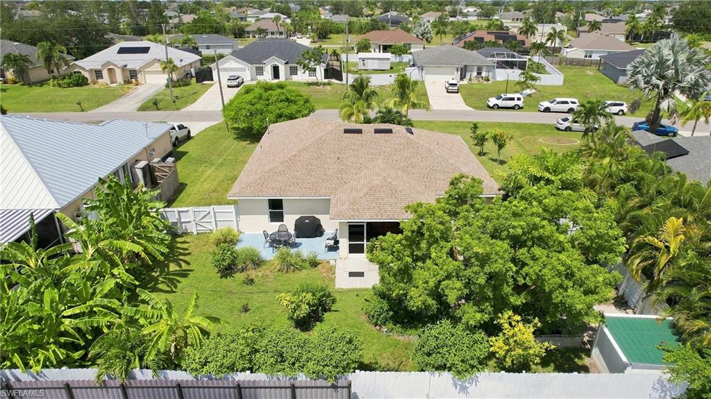 Expansive backyard featuring a manicured lawn, established landscaping, and a fenced perimeter