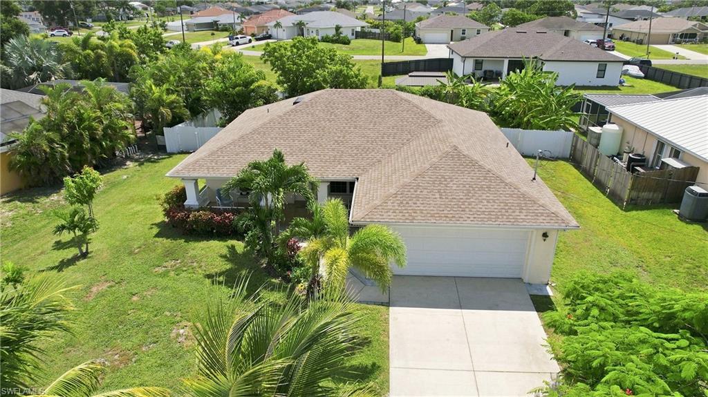 Spacious single-story residence featuring a neutral exterior, attached two-car garage, and a covered front porch with decorative columns