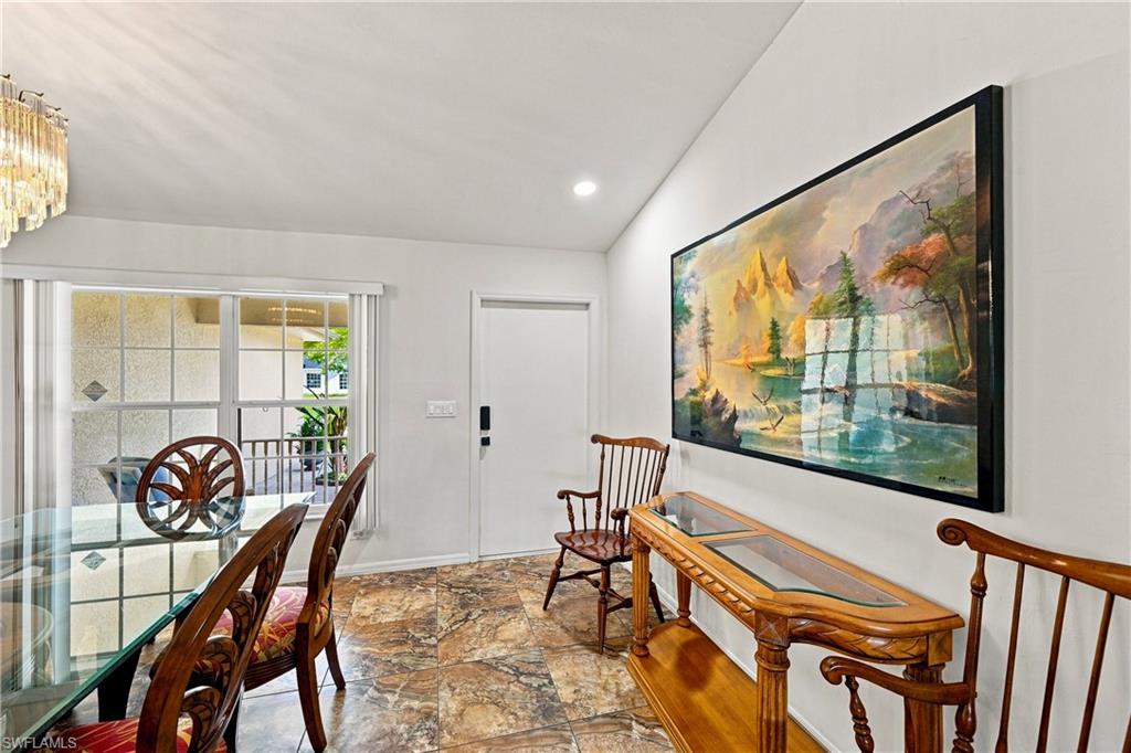 Vaulted ceiling with recessed lighting, tile flooring, and a window with horizontal blinds