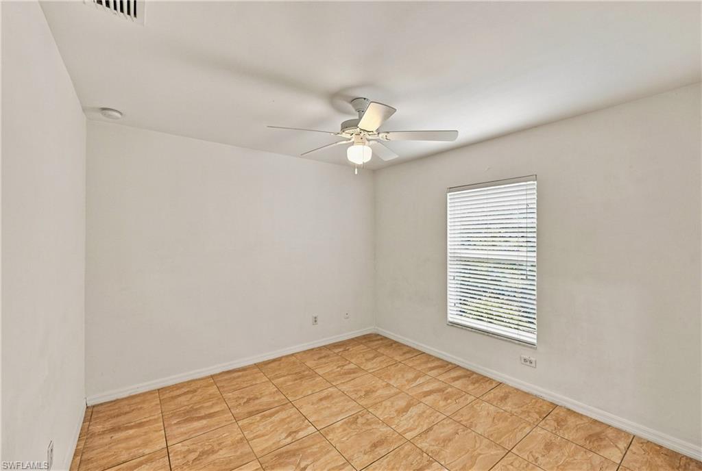 Tile flooring, neutral wall tones, ceiling fan with integrated lighting, and window with blinds