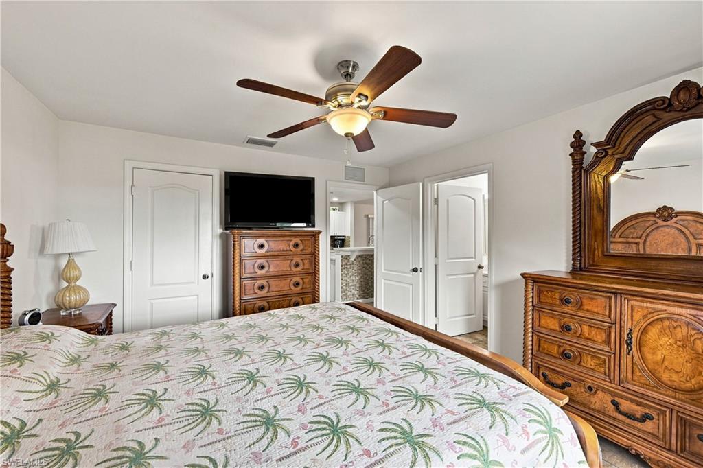 Ceiling fan with integrated lighting, white interior doors, and a tiled entry