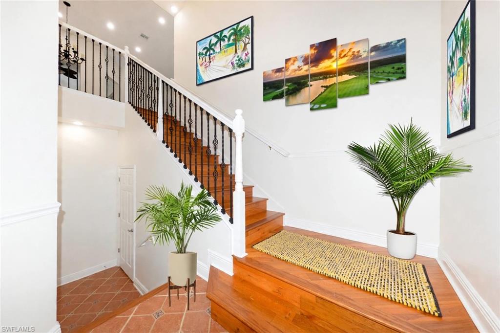 Virtually staged Entry Foyer. Upgraded stair case featuring wood stairs and iron and wood banister, Soaring ceilings with recessed lighting and crown molding.