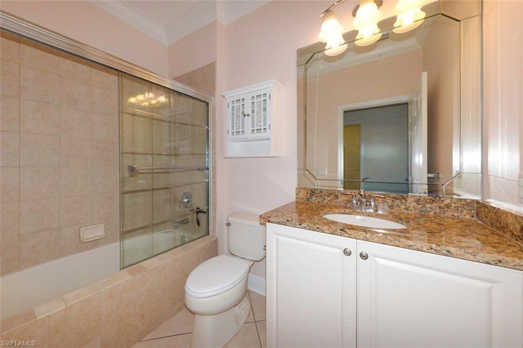 Guest bathroom with Crown molding, upgraded tile flooring, tub & shower with upgraded tile, vanity with granite counter & custom mirrors and lighting.