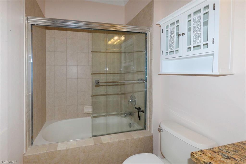 Guest bathroom with Crown molding, upgraded tile flooring, tub & shower with upgraded tile, vanity with granite counter & custom mirrors and lighting.