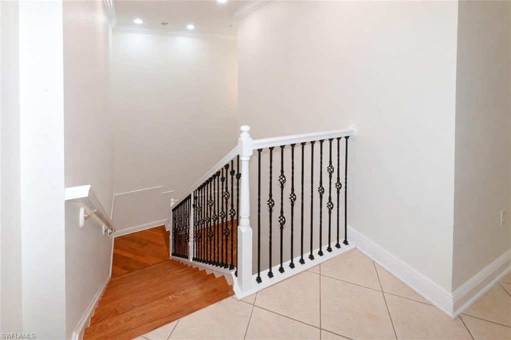 View of upgraded stair case featuring wood stairs and iron and wood banister, Soaring ceilings with recessed lighting and crown molding.