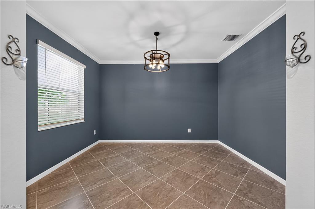 Spacious room featuring diagonal wood-finish tile flooring, slate blue walls, and white ceiling with crown molding
