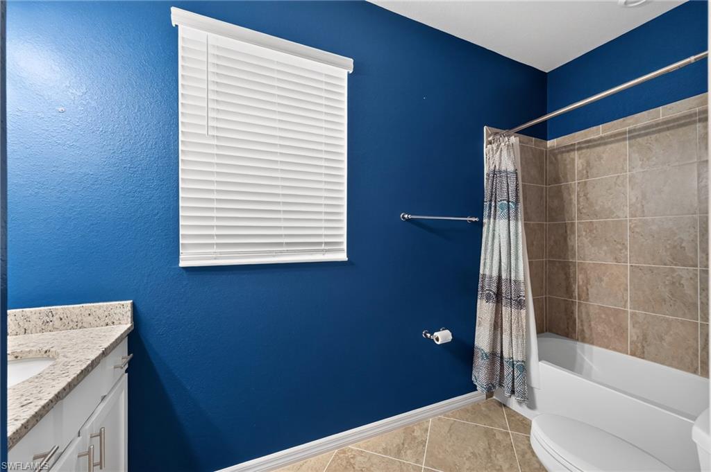 Spa-inspired bathroom featuring bold cobalt blue walls, tile flooring in warm earth tones, and a white subway tile shower surround