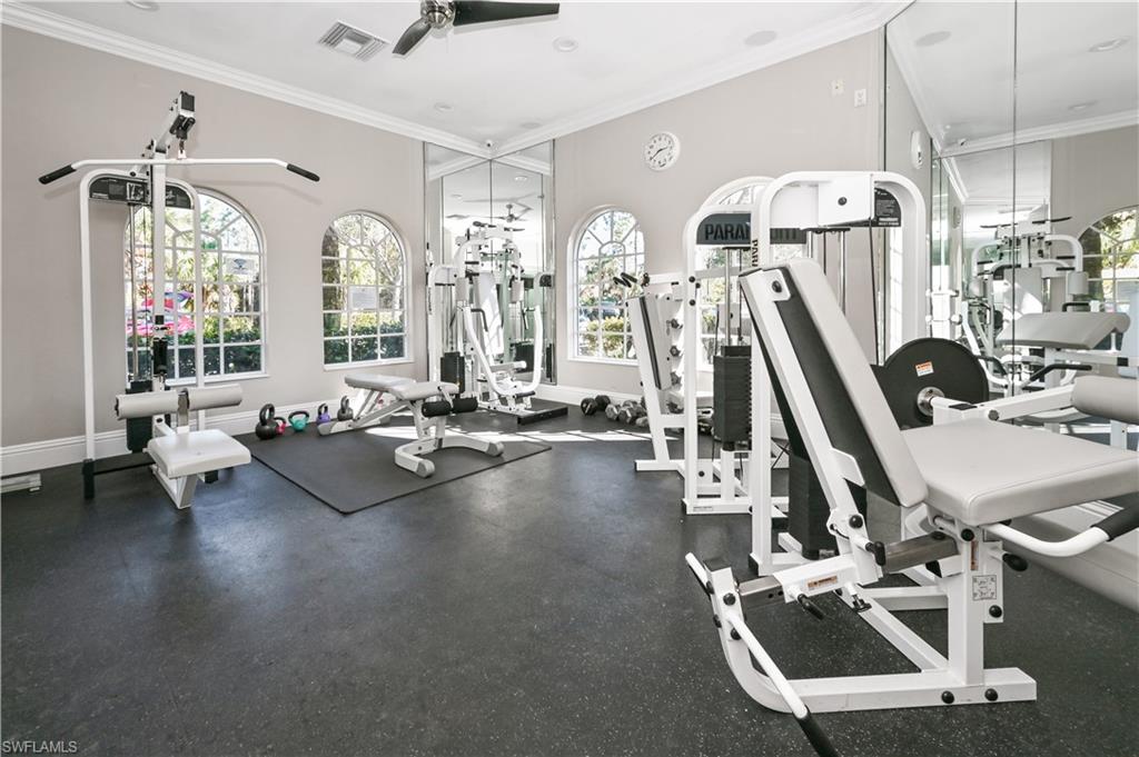 Workout area with baseboards, visible vents, ceiling fan, and crown molding