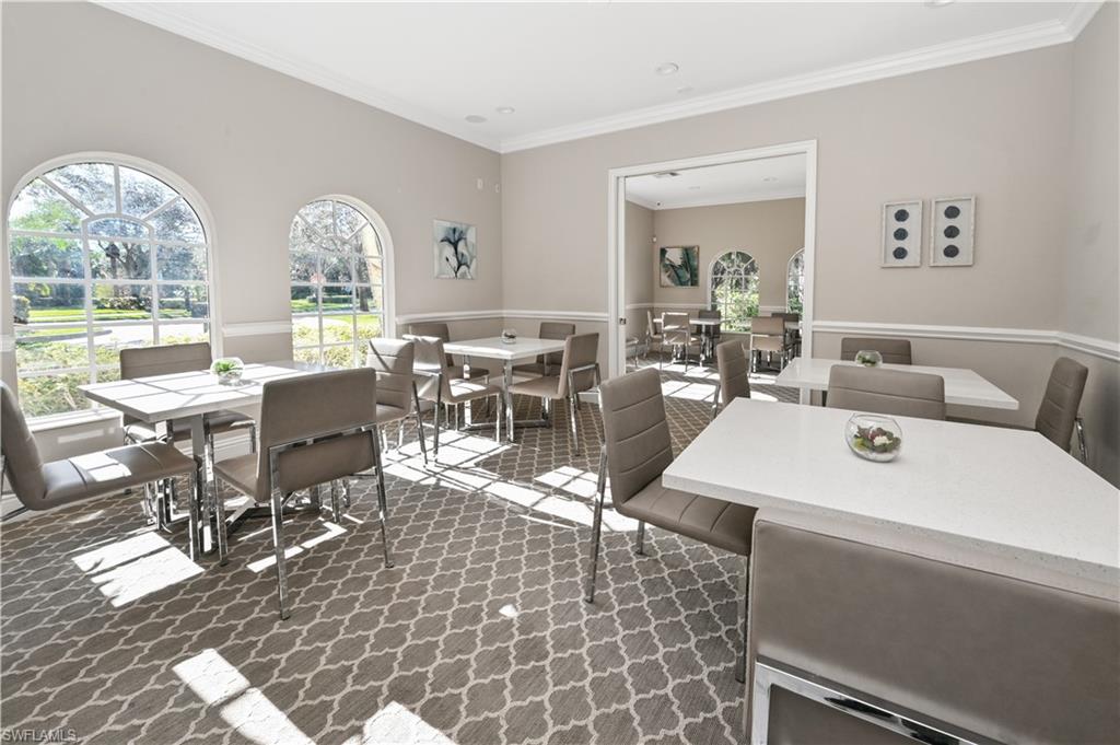 Carpeted dining area with crown molding