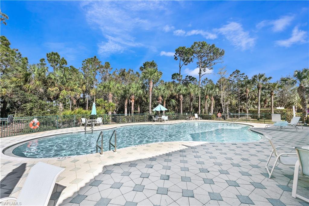 Pool with a patio area and fence