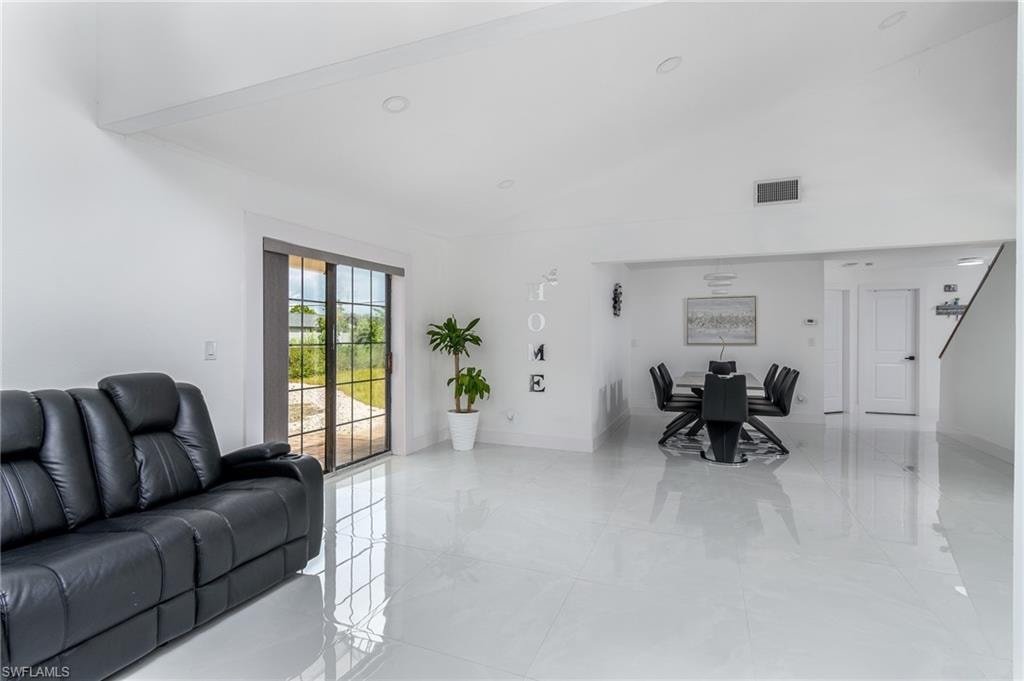 High gloss tile flooring throughout, vaulted ceilings, recessed lighting, and sliding glass doors