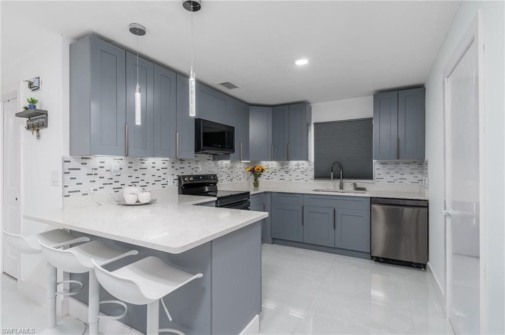 U-shaped kitchen featuring grey cabinetry, white countertops, tile flooring, and a patterned tile backsplash