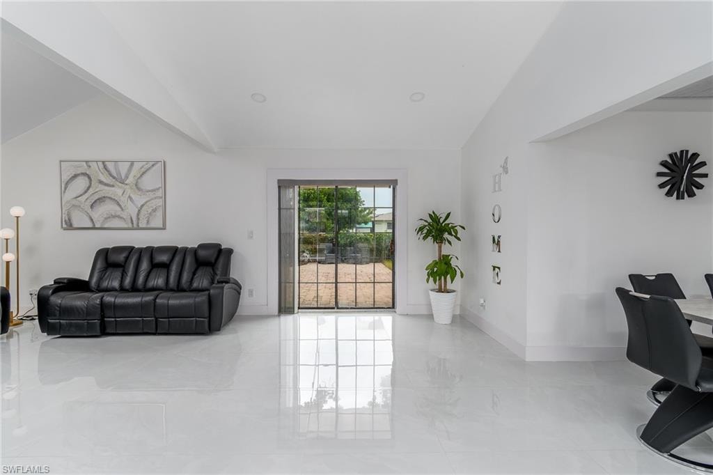 Vaulted ceilings, large format tile flooring, recessed lighting, and a rear door with multiple panes