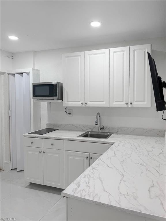 Additional garage White shaker-style cabinetry with chrome hardware, marble-patterned countertops, integrated stainless steel sink, and recessed lighting