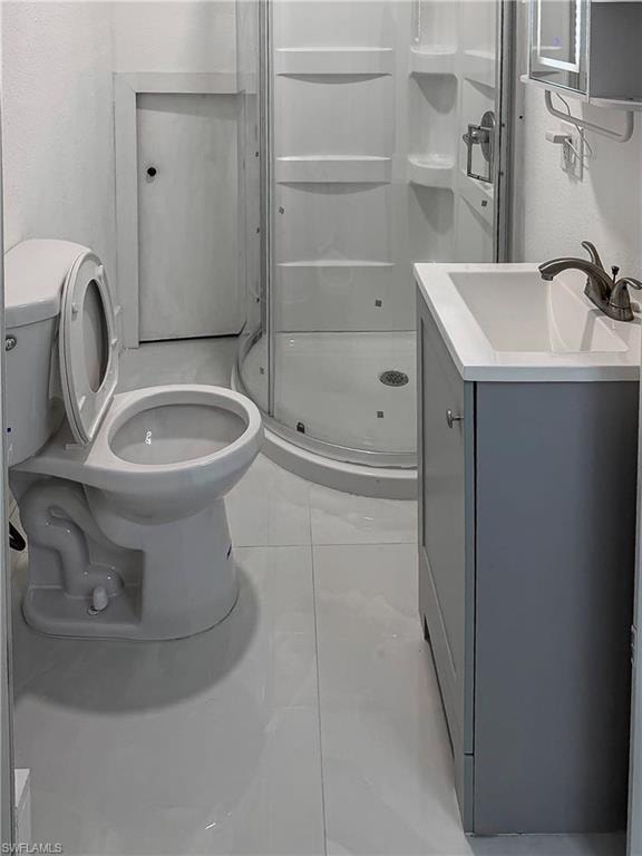 Additional garage Compact bathroom featuring a white tile floor, a contemporary vanity with a white countertop, a corner shower enclosure, and a standard toilet