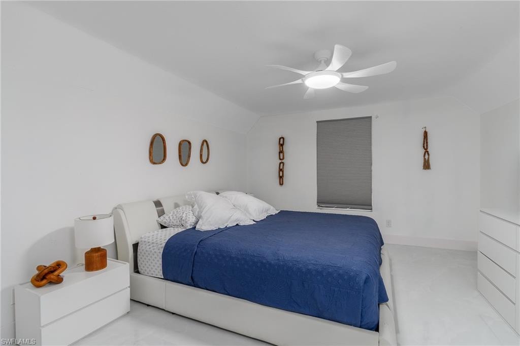 White walls, modern ceiling fan with integrated lighting, window with gray blind, and light-colored flooring