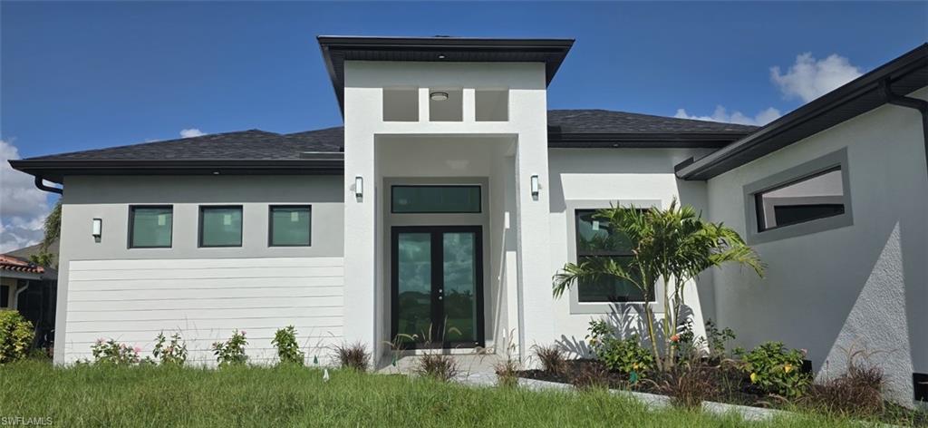 Modern exterior with a contrasting dark roof, black-framed windows, and double entry doors