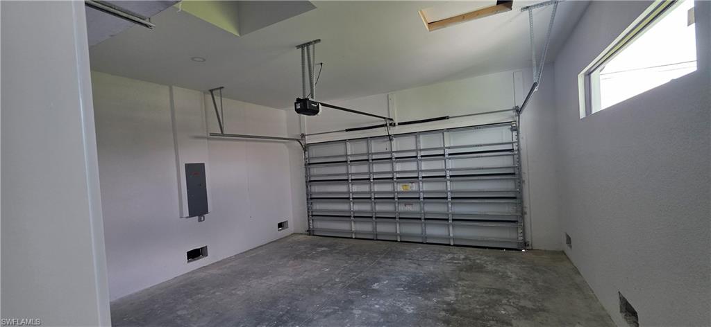 Enclosed garage with a metal sectional door, automatic door opener, and high-set window
