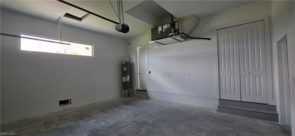 Garage with concrete flooring, a horizontal window, and white bi-fold doors