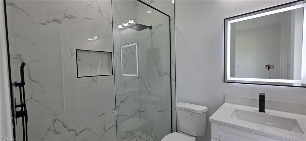 Full-height tiled shower with a black-framed glass enclosure