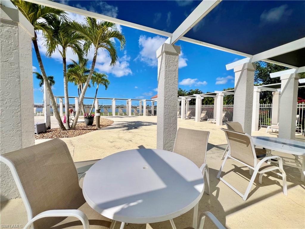 View of cabana featuring outdoor dining space and fence