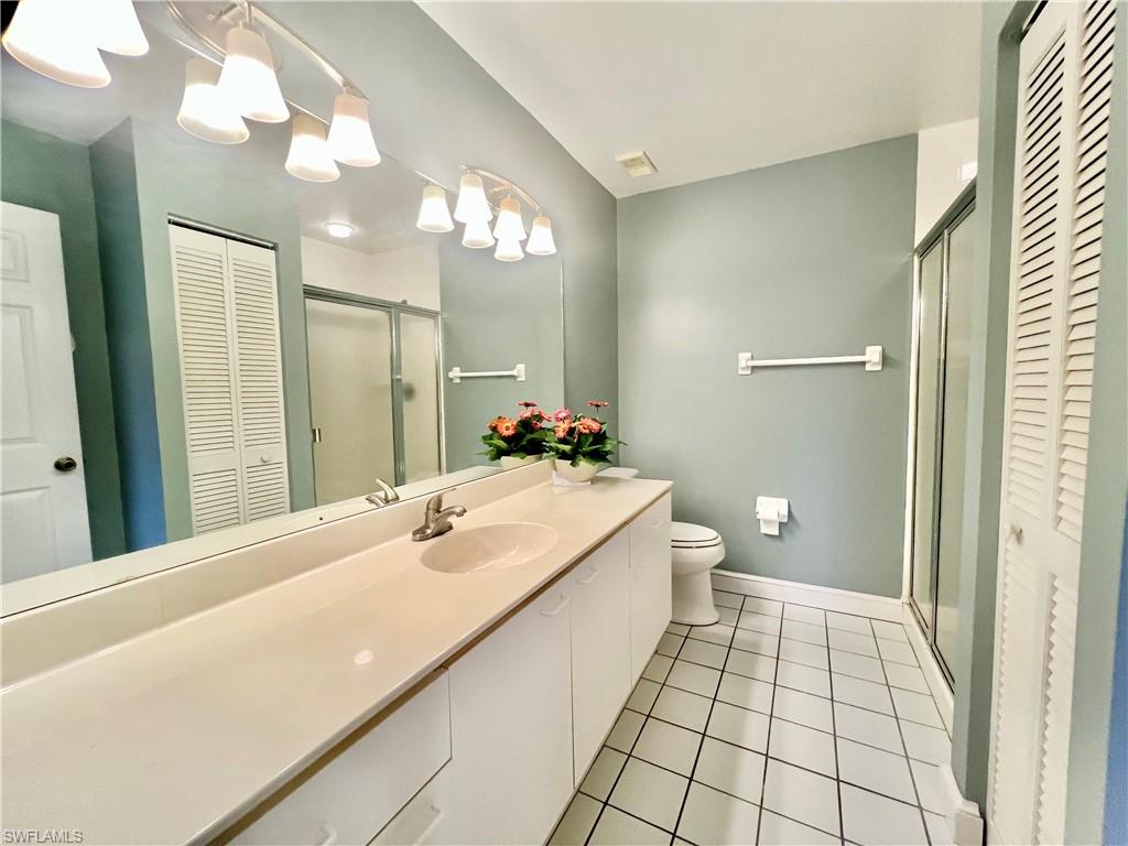 Master Bathroom featuring a closet, tile patterned floors, vanity, toilet, and a shower stall
