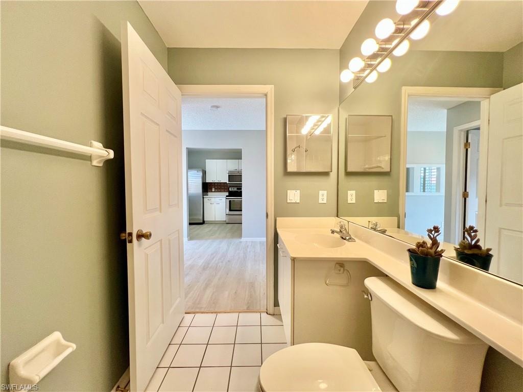 Guest Bathroom with toilet, tile patterned flooring, and vanity
