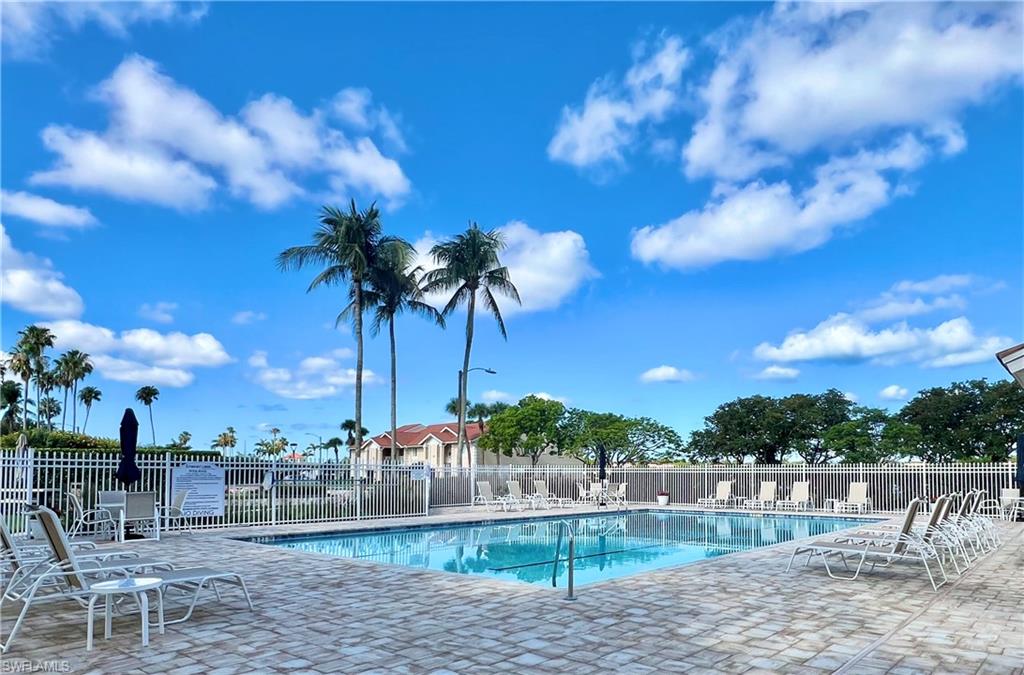 Community pool featuring fence and a patio area