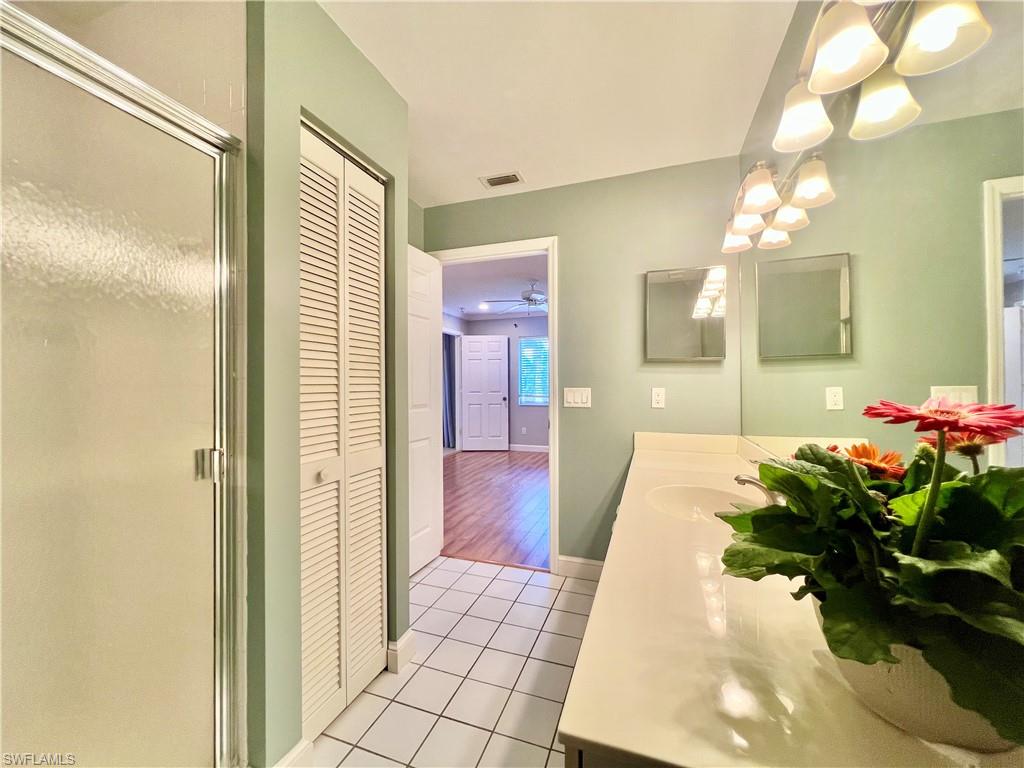 Master Bathroom with a closet, tile patterned floors, vanity, a chandelier, and a shower stall