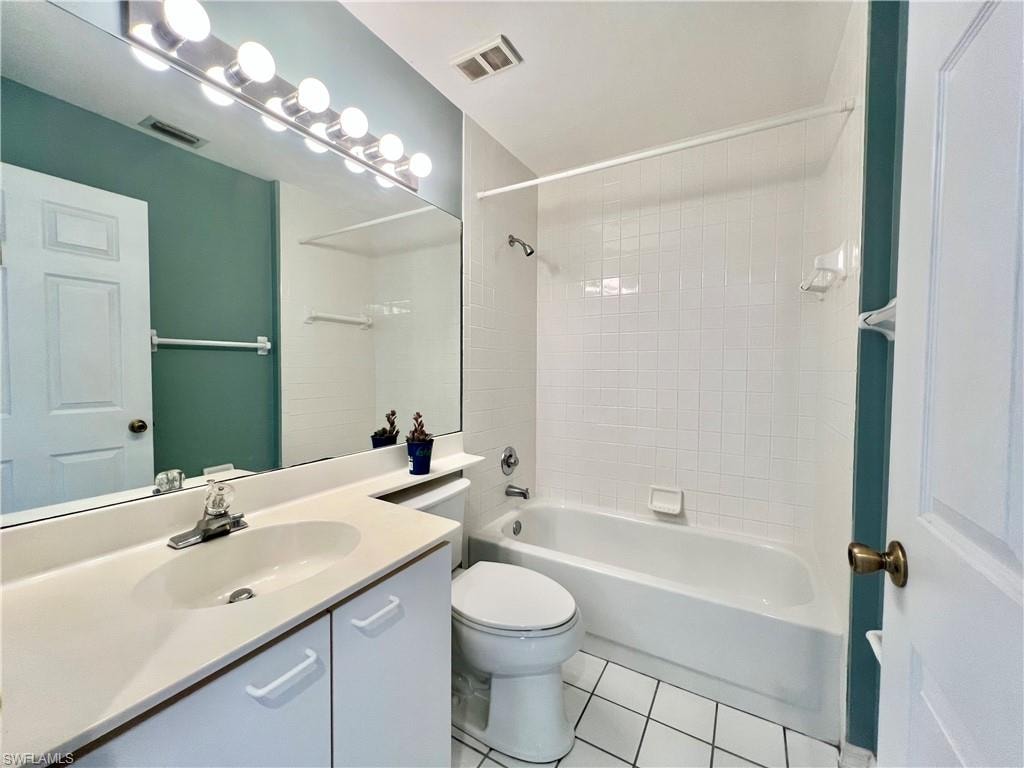 Guest Bathroom featuring tile patterned floors, toilet, bathing tub / shower combination, and vanity