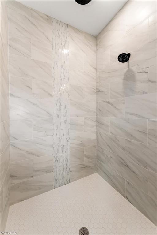 View of the primary shower with a brick pattern layout with a glass tile accent. This looks fantastic!
