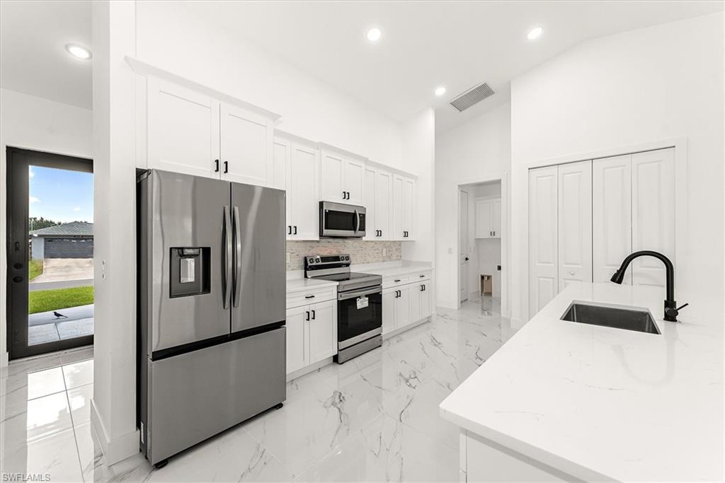 Kitchen view with the large pantry off the side of the island area.