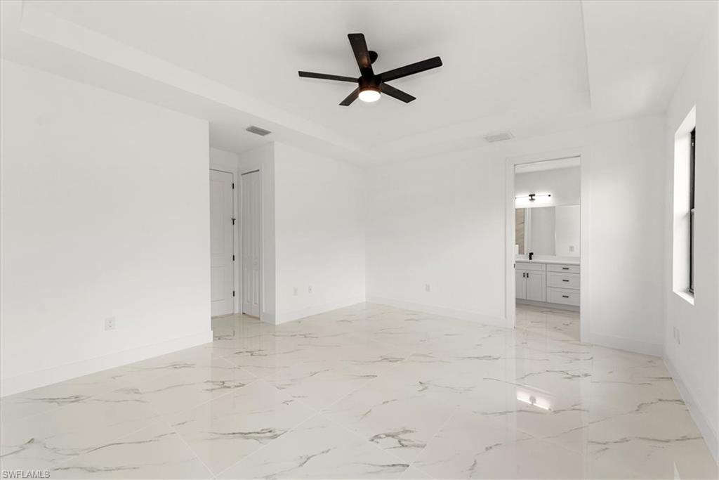 This view of the primary bedroom shows the entry to the left which has two large walk in closets. The primary bath is in the right side of the picture