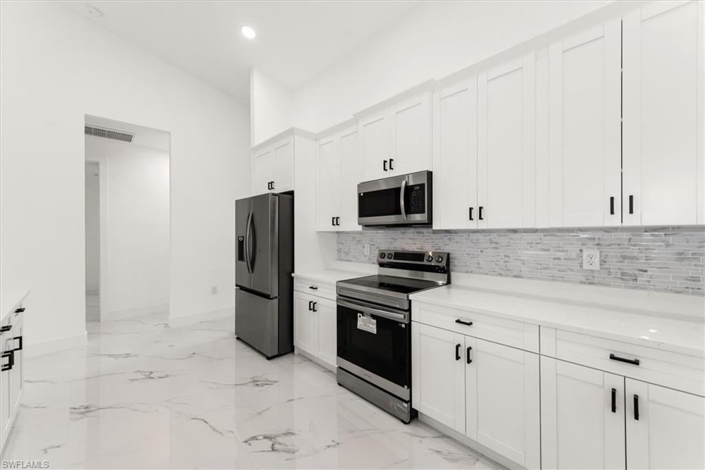 The kitchen includes SS Samsung kitchen appliances, 42" high wall cabinets with crown molding, a glass tile backsplash, and all the cabinets are soft close. Quart countertops are used throughout the home.
